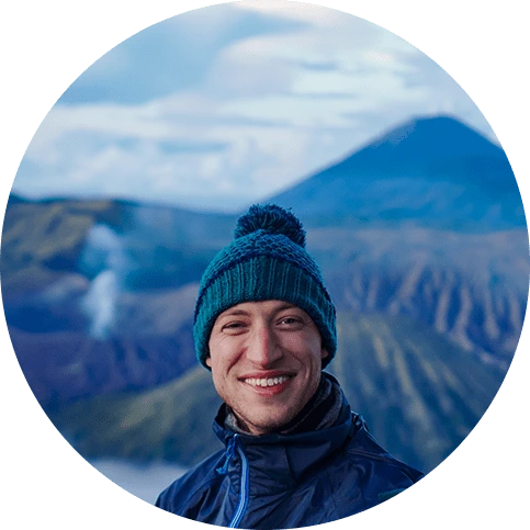 A picture of me wearing a blue raincoat with a volcano in the back-drop, mount bromo to be specific in Indonesia